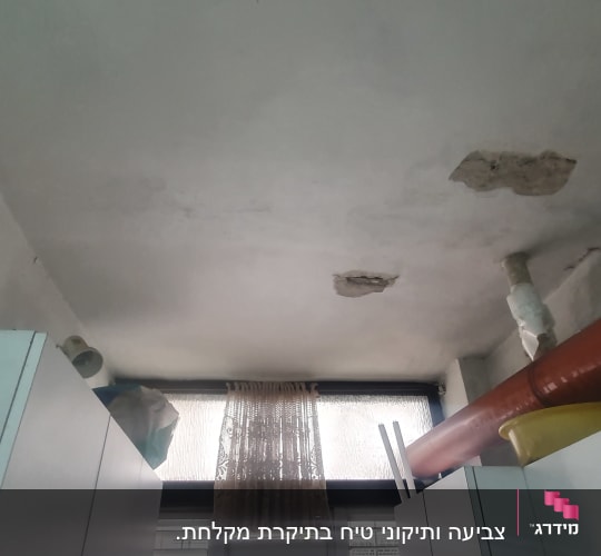 תקרה עם קילופי צבע ותיקונים נראים